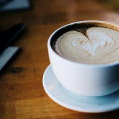 A cappuccino with a foam heart in a white cup