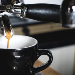 An espresso shot pulling into a black cup